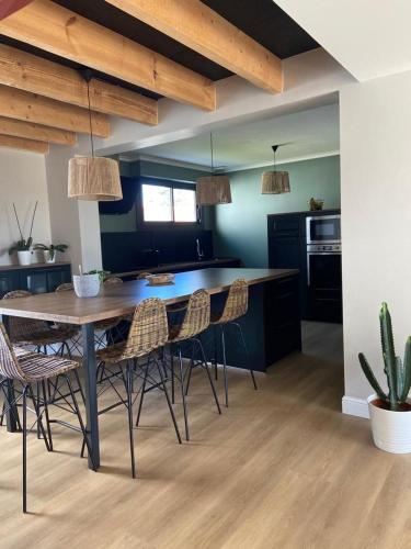 - une cuisine avec une table et des chaises en bois dans la chambre dans l'établissement Jolie villa face aux dunes et mer, à Bretignolles-sur-Mer