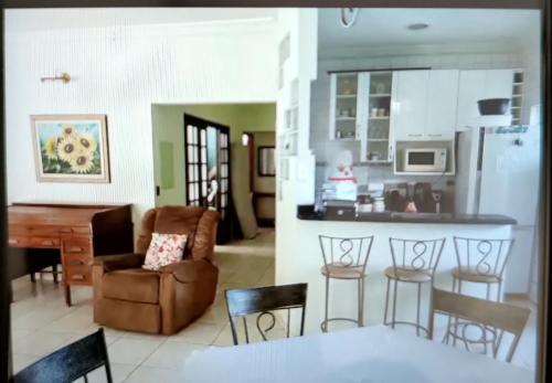 uma cozinha e uma sala de estar com mesa e cadeiras em Casa 3 suítes no centro de Cuiabá em Cuiabá