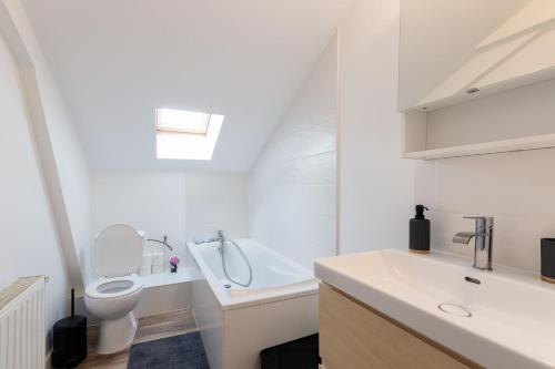 une salle de bain blanche avec des toilettes et un lavabo dans l'établissement Le Carnot, à Homécourt