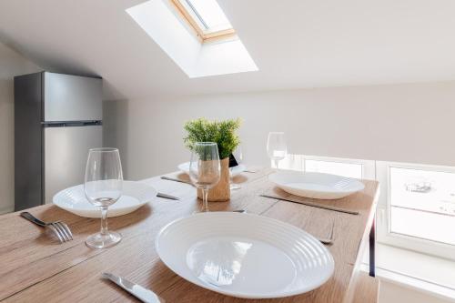 - une table à manger avec des assiettes blanches et des verres à vin dans l'établissement Le Carnot, à Homécourt