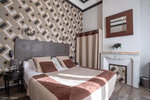 a bedroom with a large bed and a fireplace at Hôtel de Charme Le Provence in Salon-de-Provence