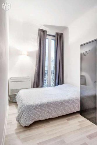 une chambre avec un lit et une fenêtre dans l'établissement Le Baille Coeur centre Ville, à Marseille