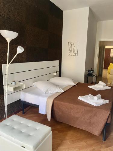 a bedroom with two beds and a lamp at Via del Corso Room&Suite in Matera