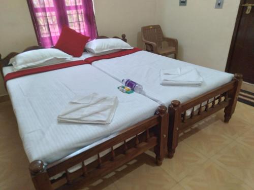 a bed with white sheets and a hospital at Homely Home stay in Kalpetta