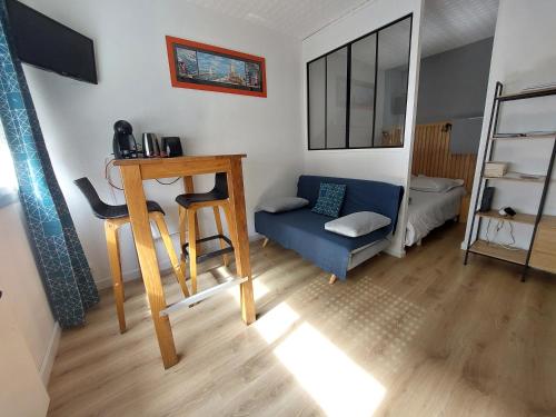 sala de estar con sofá azul y mesa en Studio la Salicorne au Sables d'Olonne, en Les Sables-dʼOlonne