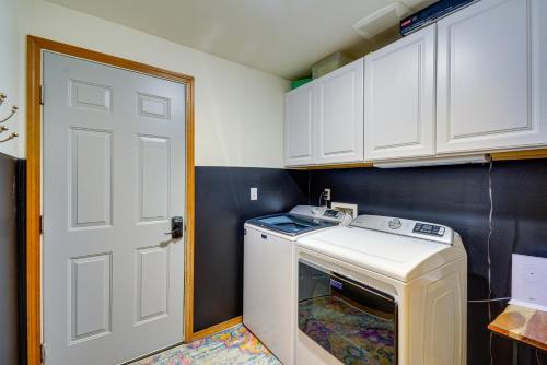 uma pequena cozinha com uma máquina de lavar roupa e uma porta em Gig Harbor Vacation Rental with Private Hot Tub! em Gig Harbor