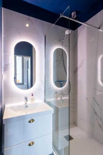 une salle de bain avec deux lavabos et deux miroirs dans l'établissement Appartement T4 cours Julien proche Vieux-Port - parking gratuit, à Marseille
