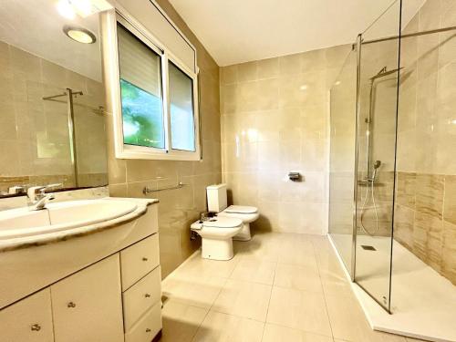 La salle de bains est pourvue de toilettes, d'un lavabo et d'une douche. dans l'établissement Villa Avondale 3bedroom villa with air-conditioning & private swimming pool, à L'Ametlla de Mar