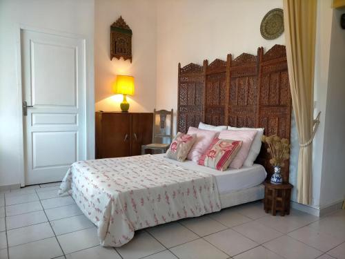 1 dormitorio con 1 cama grande con almohadas rosas en Mas des Marbres Sauvages - la Grange 6 chambres grand parc à 3 km de la plage, en Sainte-Marie-la-Mer