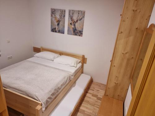 a bedroom with a bed and two pictures on the wall at Bolfenk Snowflake app in Hočko Pohorje