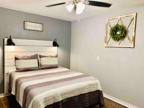 Schlafzimmer mit einem Bett und einem Deckenventilator in der Unterkunft Casita Blanca- Close To Downtown in Waco