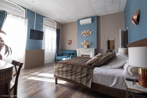 a bedroom with a large bed and blue walls at Hôtel de Charme Le Provence in Salon-de-Provence