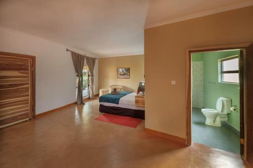 1 dormitorio con cama y aseo en The Nkhosi Livingstone Lodge and Spa en Livingstone