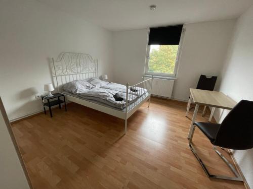 a bedroom with a bed and a table and a window at Schönes einfaches Zimmer zentral in Wilhelmshaven in Wilhelmshaven