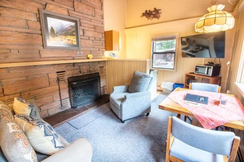 a living room with a fireplace and a table and chairs at Castle Mountain Lodge in Estes Park