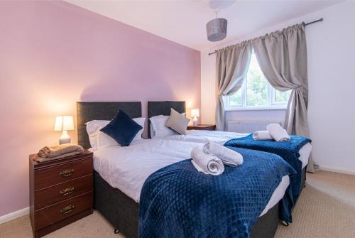 a bedroom with two beds with towels on them at Derby Wilson Ave - Spacious 2 Bedroom Apartment with Garden in Derby
