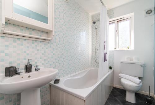 a white bathroom with a sink and a toilet at Derby Wilson Ave - Spacious 2 Bedroom Apartment with Garden in Derby