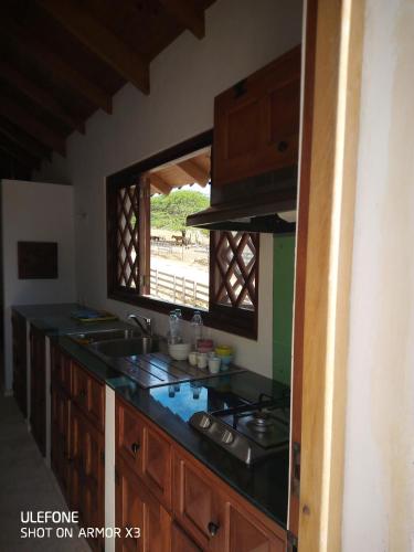 a kitchen with a counter with a sink and a window at La Capilla tropical in Puerto de Luperon