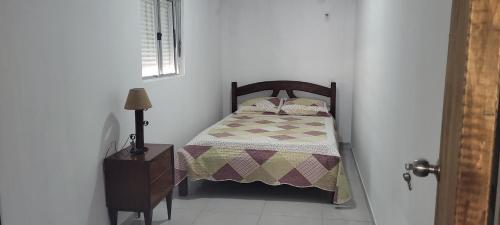 um pequeno quarto com uma cama e uma mesa de cabeceira e uma cama sidx sidx sidx em Apartamento Romian 2 em Paysandú
