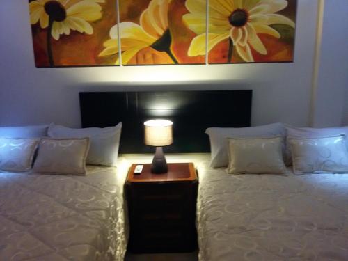 a bedroom with a bed with a lamp on it at Hotel Las Mercedes Airport-Quito in Tababela