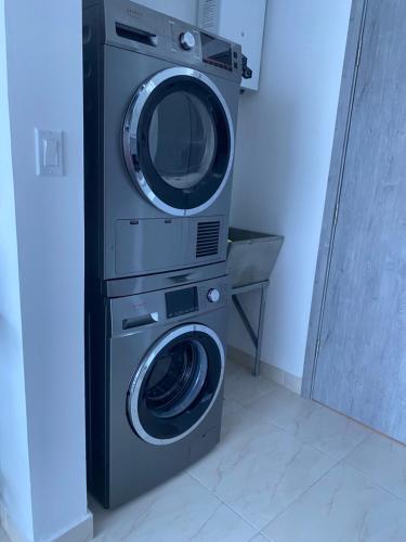 a washing machine and a washer and dryer in a room at Apartamento con piscina infinita frente al mar en Avenida Balboa PH The Sand in Panama City