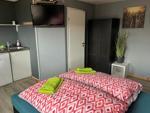 a bedroom with a bed with green towels on it at Flensburg City - 24h in Flensburg