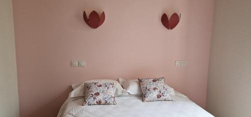 a bedroom with a bed with two hearts on the wall at Hotel ChezJeanne in La Bourboule
