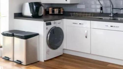 a kitchen with a washing machine and a sink at Deutinger Ferienhaus-Oberammergau in Oberammergau