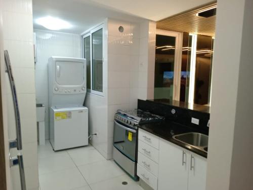 a small kitchen with a refrigerator and a dishwasher at 1a in Panama City