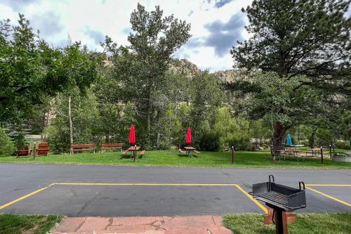 a parking lot with benches and red umbrellas in a park at Castle Mountain Lodge in Estes Park