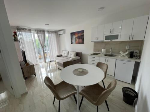 a kitchen and living room with a white table and chairs at Apartman Zivkovic in Veliko Gradište