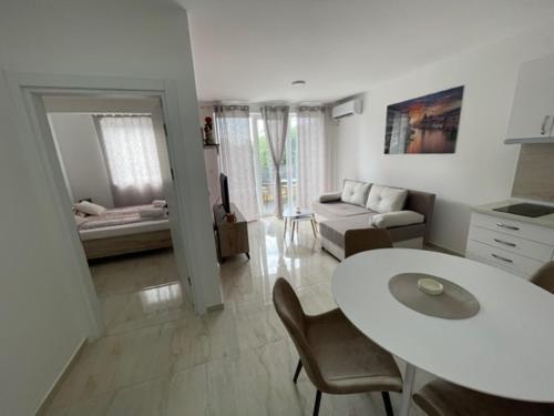a white living room with a table and a couch at Apartman Zivkovic in Veliko Gradište