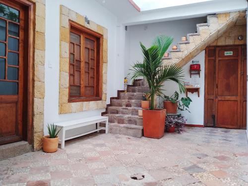 uma casa com escadas e vasos de plantas ao lado de uma porta em Casita de Piedra em Bogotá