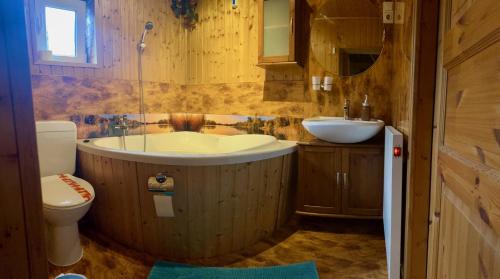 a bathroom with a tub and a sink and a toilet at Norwegisches Holzhaus in Neuruppin
