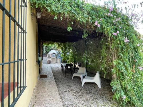 a pergola with chairs and flowers on a building at Casas Amarillas. Finca el Campillo in Blanca
