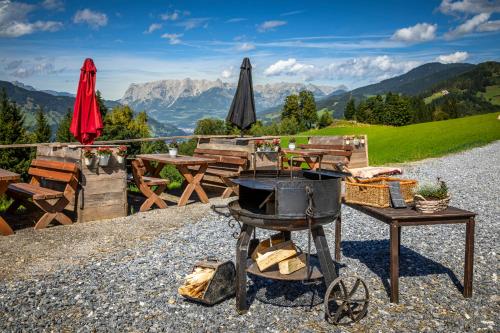 a grill on a table with a view of mountains at Taurachhof Astlehen in Alpendorf