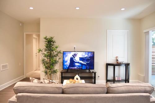 a living room with a couch and a flat screen tv at Creek Side 2-Bedroom Guest Suite in Burnaby