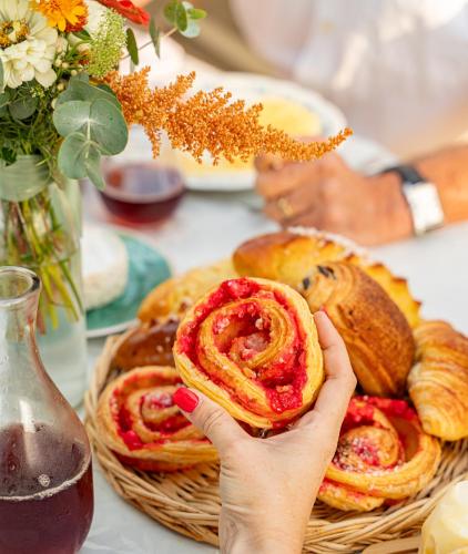 a person holding a pastry in front of a basket of bread at LE DOMAINE DE GORNETON in Chasse-sur-Rhône
