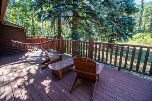 a deck with two benches and a hammock on it at Castle Mountain Lodge in Estes Park