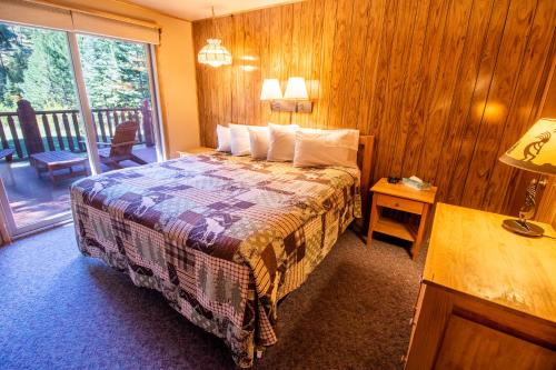 um quarto de hotel com uma cama e uma varanda em Castle Mountain Lodge em Estes Park