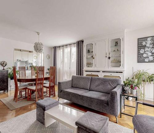 ein Wohnzimmer mit einem Sofa und einem Tisch in der Unterkunft Appartement 2 chambres in Romans-sur-Isère