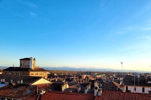 a view of a city with roofs and mountains in the background at Le Stanze del Cardinale in Pavia