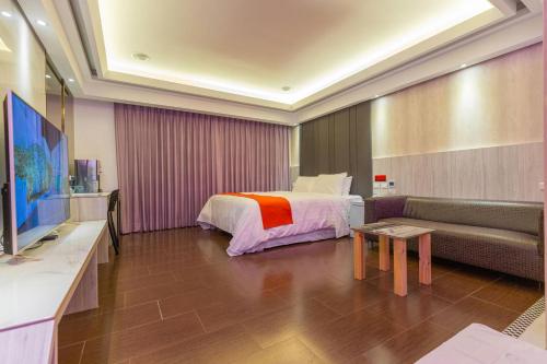 a hotel room with a bed and a couch at King Motel王者 in Taoyuan