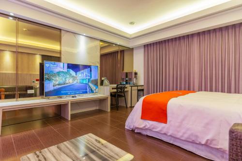 um quarto de hotel com uma cama e uma televisão de ecrã plano em King Motel王者 em Taoyuan