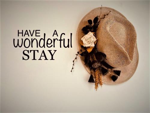 a hat hanging on a wall with the words have a wonderful stay at Wisteria in Nafpaktos