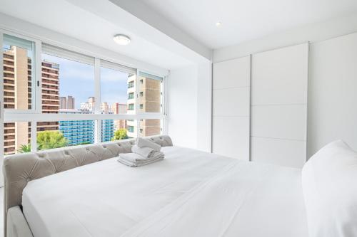 um quarto branco com uma grande cama branca e uma janela em Versalles 732 Apartment Levante-Rincon Loix Area em Benidorm