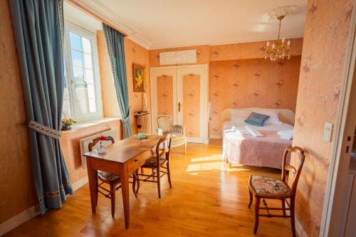 een slaapkamer met een bed en een tafel en stoelen bij RELAIS SAINT JACQUES in Amboise