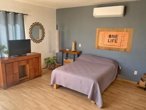 um quarto com uma cama e uma televisão e um sinal de vida em Exclusivo Loft en Santa Anita em Santa Anita