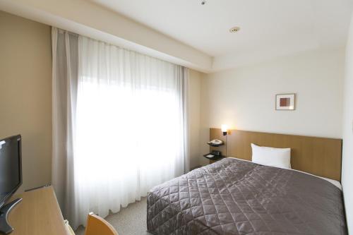 a bedroom with a bed and a large window at OU Hotel in Yonago