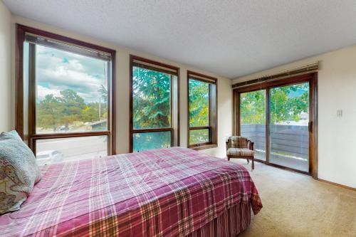 um quarto com janelas e uma cama com um cobertor roxo em Gold Creek 208 em Angel Fire